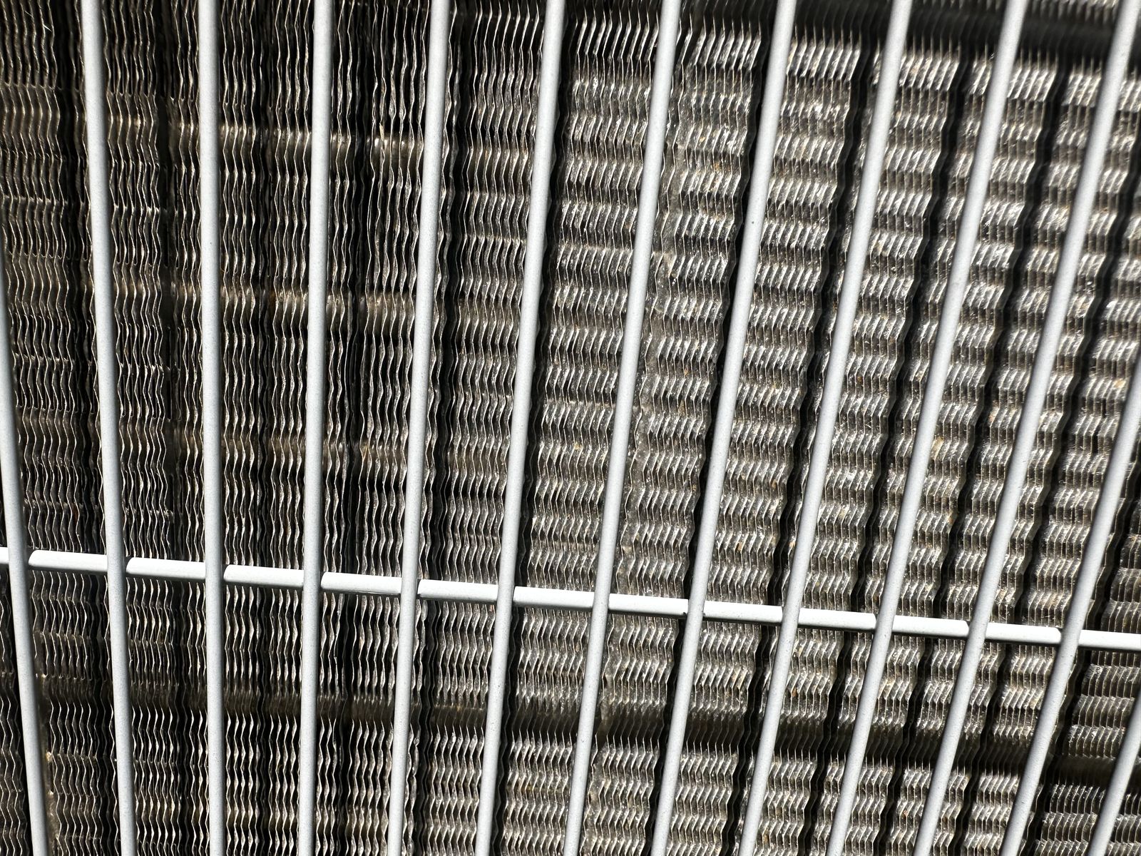 Freshly cleaned AC condenser coil after professional maintenance